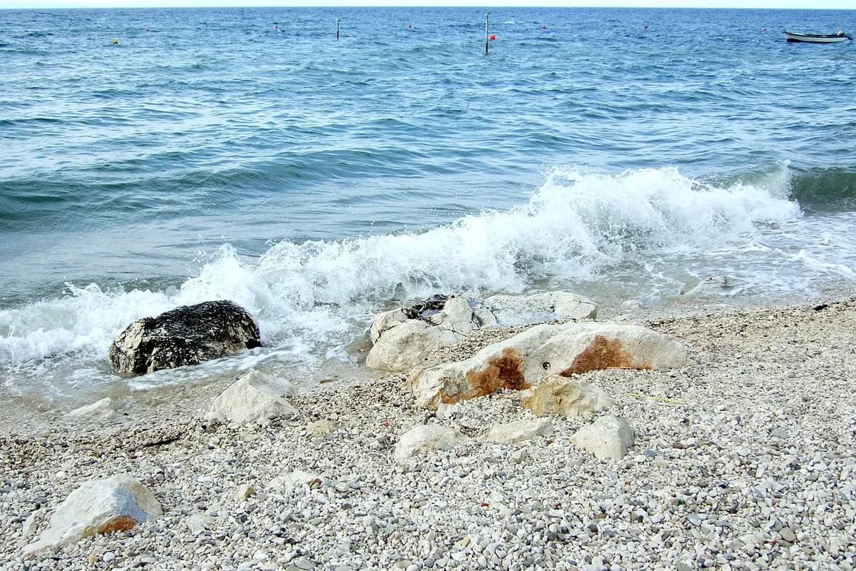Pebble beach in Split, Croatia with swimmers in turquoise water